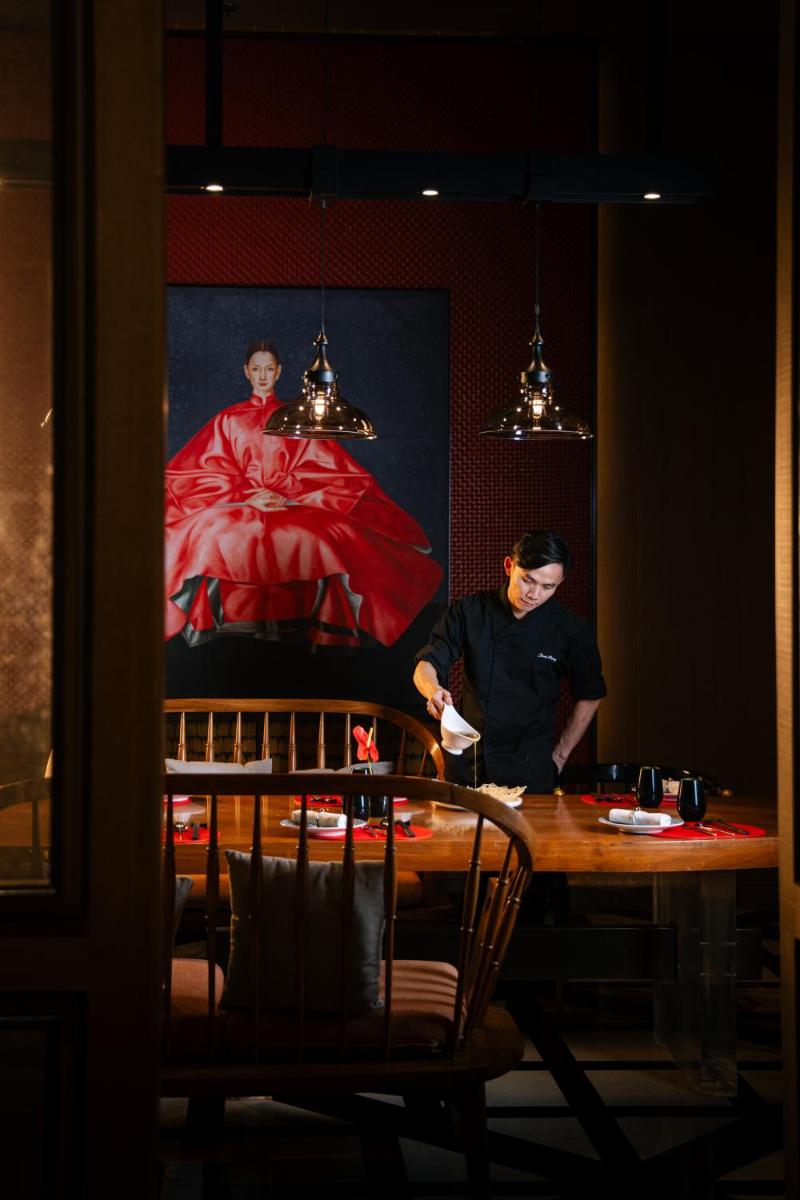 a woman standing at a table in front of a painting at JW Marriott Hotel Kolkata in Kolkata