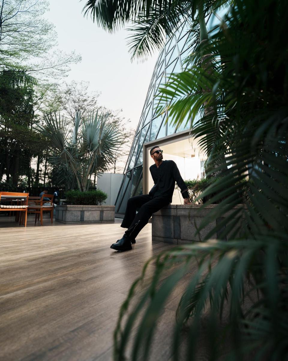 a man sitting on a ledge in front of a building at JW Marriott Hotel Kolkata in Kolkata