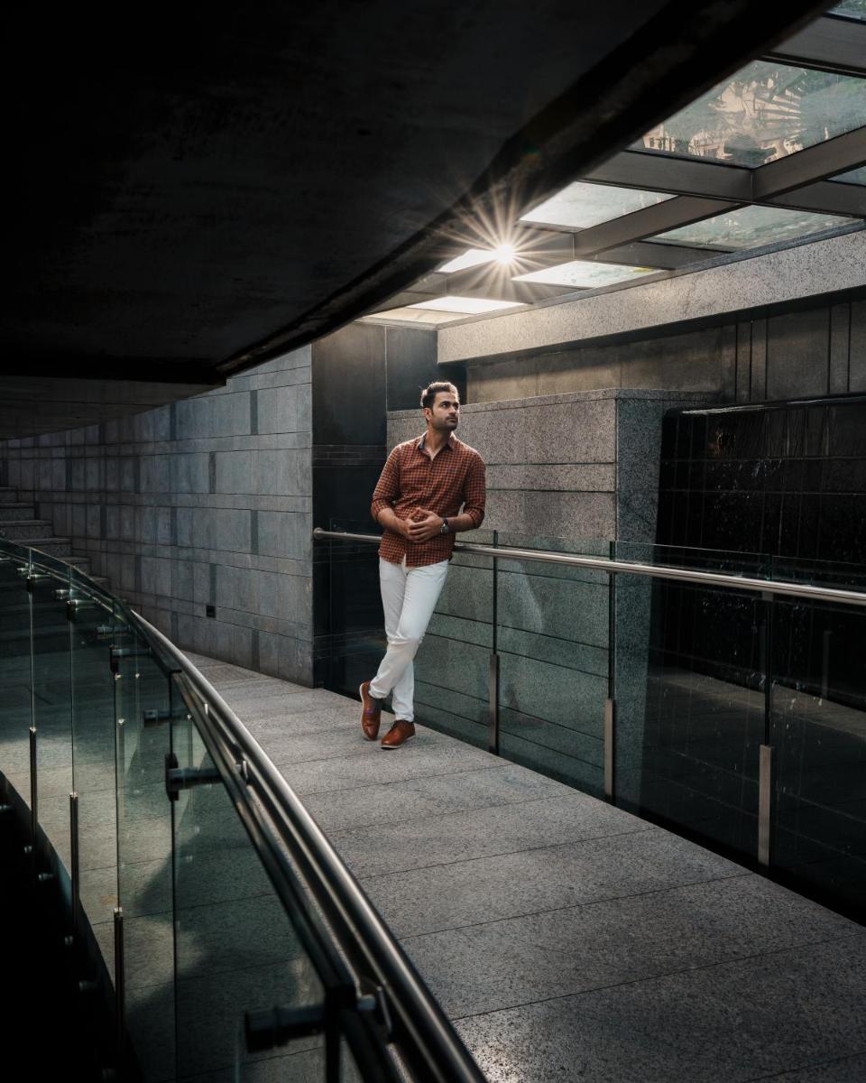 a man is standing on a walkway in a building at JW Marriott Hotel Kolkata in Kolkata