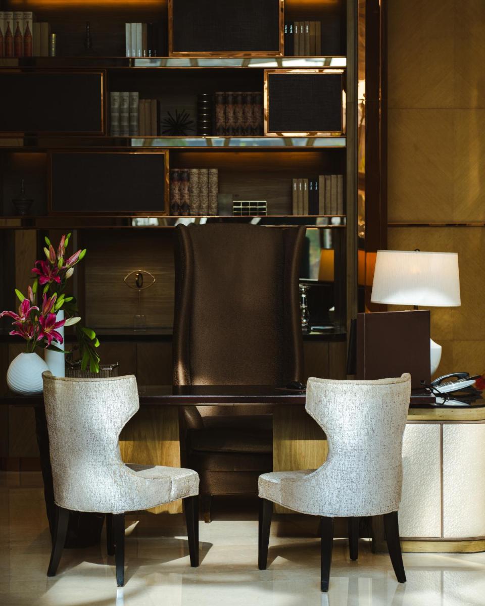 a desk with two chairs and a table with a lamp at JW Marriott Hotel Kolkata in Kolkata