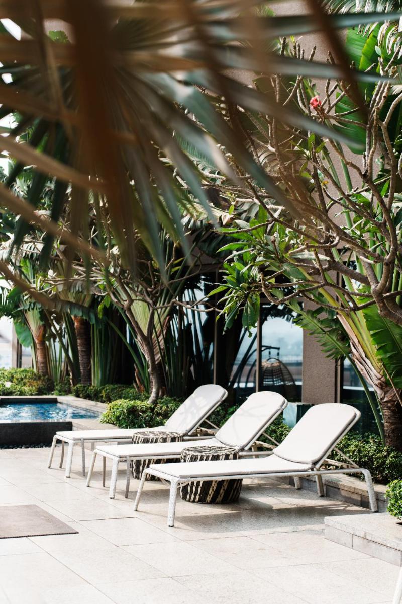 a row of white lounge chairs next to a pool at JW Marriott Hotel Kolkata in Kolkata
