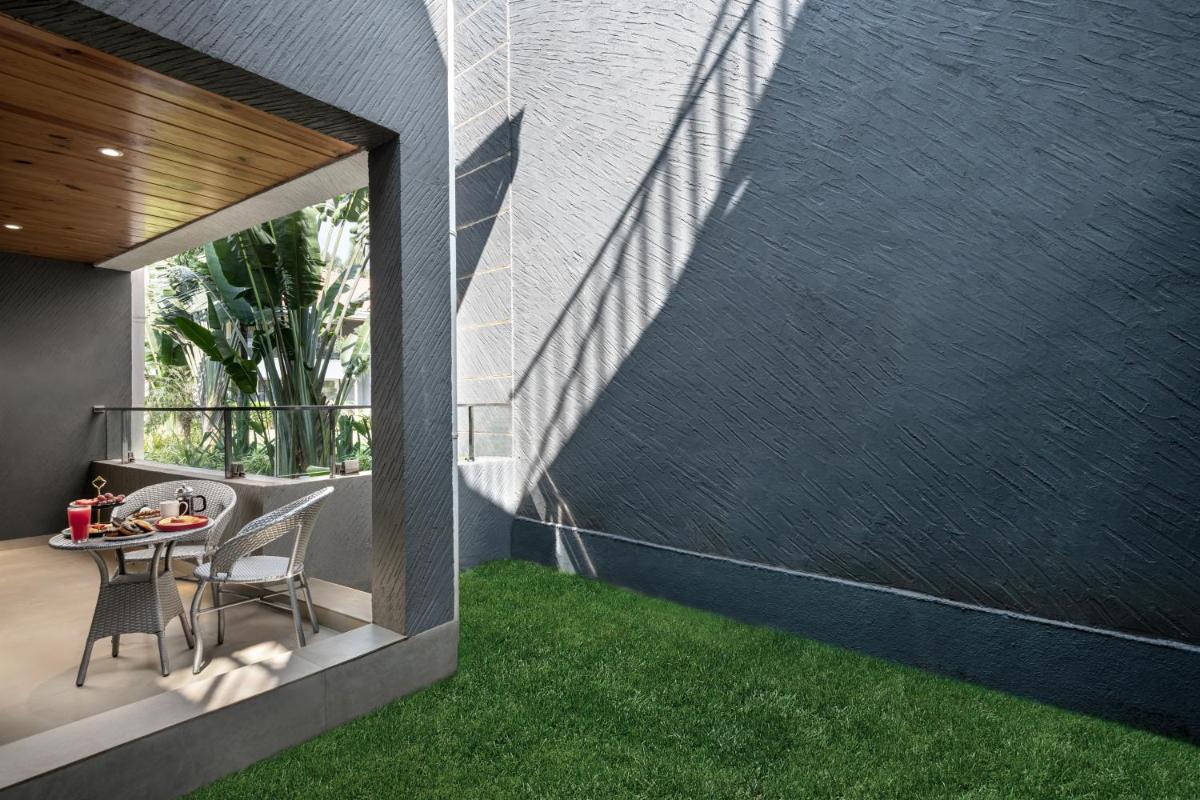 a room with a table and chairs on a balcony at Hyatt Place Goa Candolim in Candolim a room with a table and chairs on a balcony at Hyatt Place Goa Candolim in Candolim