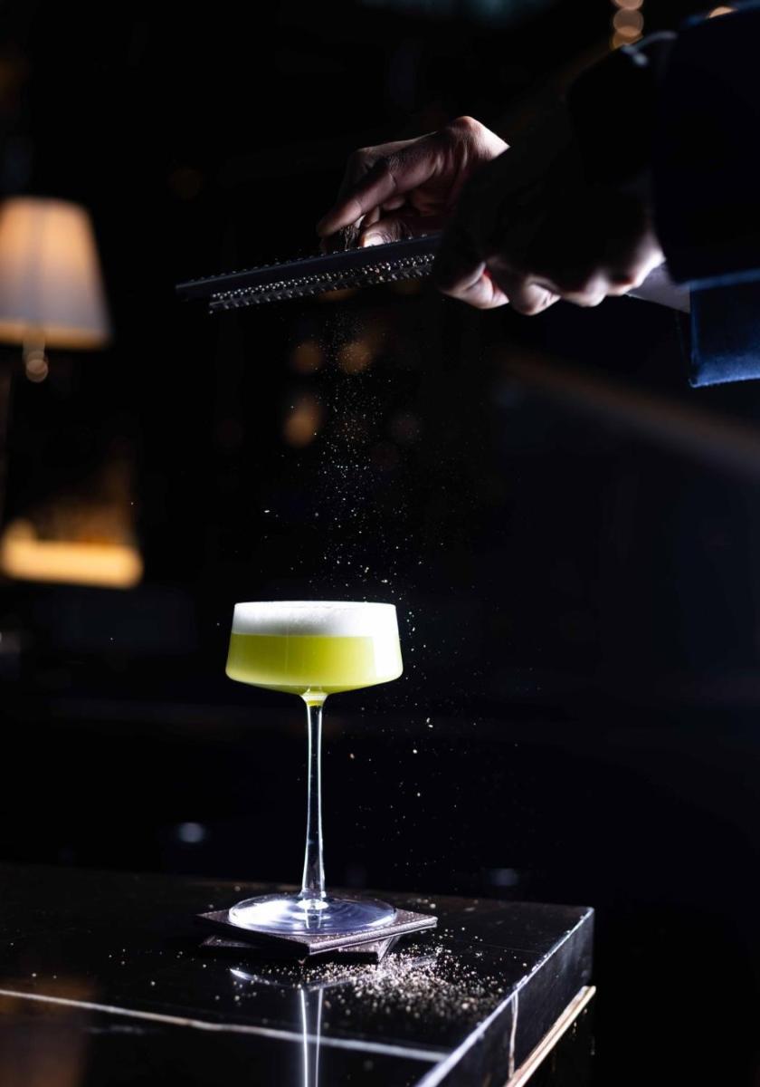 a person is pouring a drink into a wine glass at JW Marriott Hotel Kolkata in Kolkata