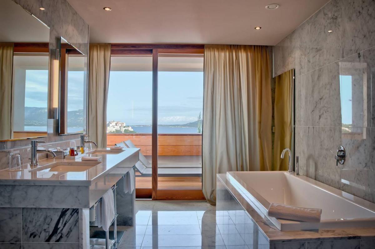 une salle de bain avec deux lavabos et une baignoire dans l'établissement La Villa Calvi, à Calvi une salle de bain avec deux lavabos et une baignoire dans l'établissement La Villa Calvi, à Calvi