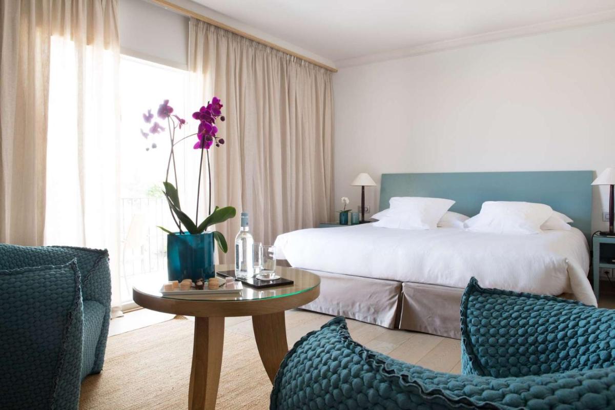 une chambre d'hôtel avec un lit, une table et des chaises dans l'établissement La Villa Calvi, à Calvi 108 autres photos