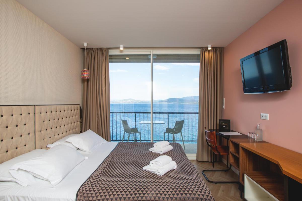 une chambre d'hôtel avec un lit et une télévision dans l'établissement Hotel La Pietra Restaurant & Spa, à LʼÎle-Rousse