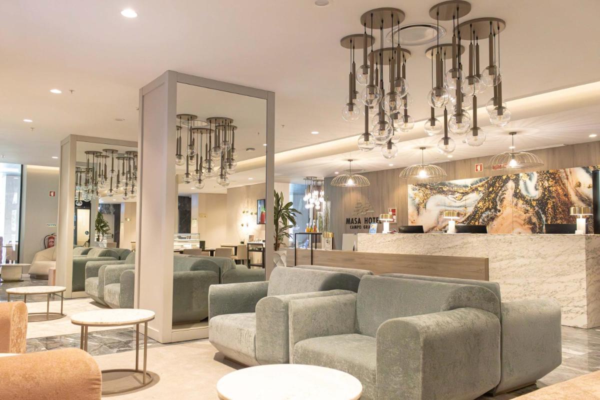 uma sala de estar com sofás, mesas e espelhos em MASA Hotel & Spa Campo Grande Collection em Lisboa