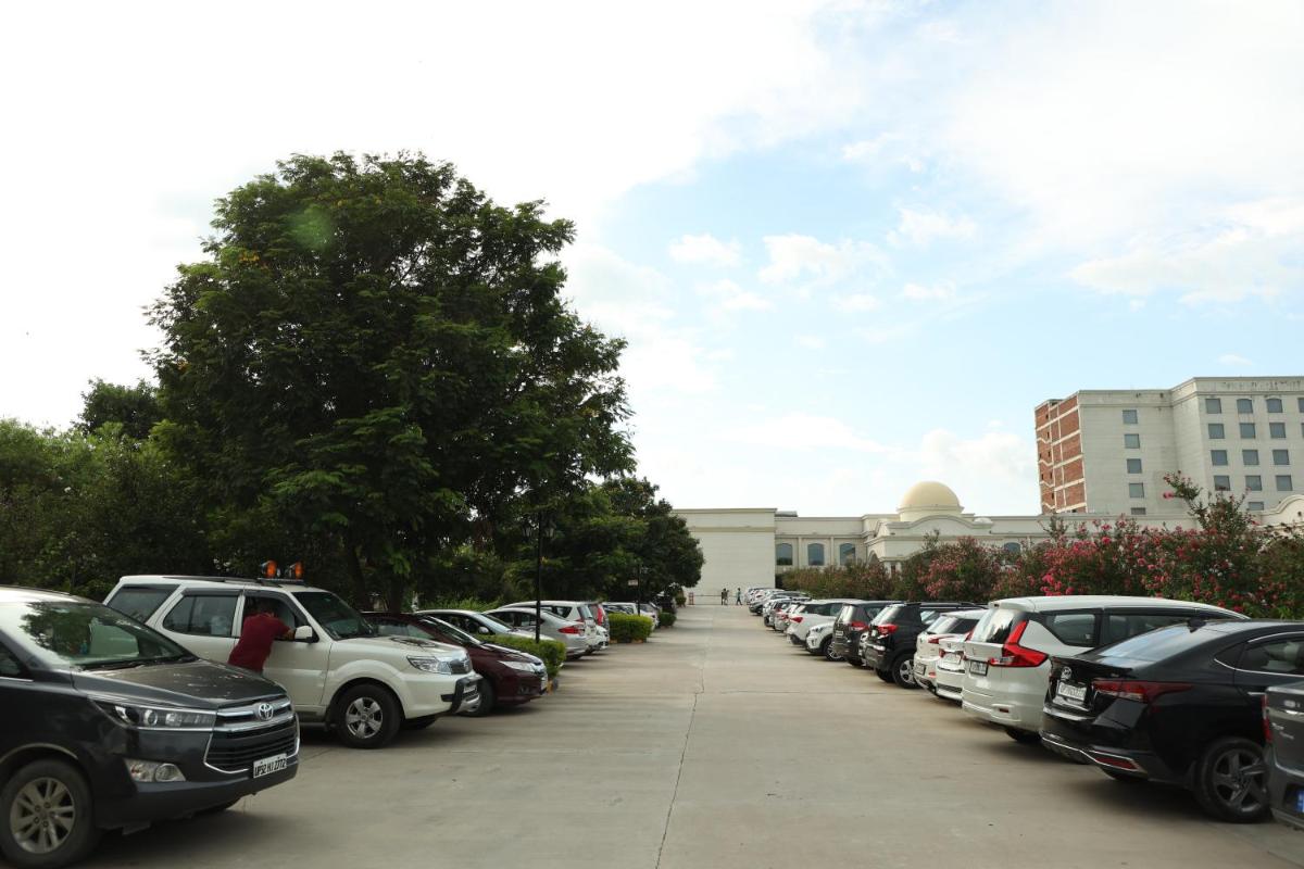 a row of cars parked in a parking lot at Ramada by Wyndham Lucknow Hotel and Convention Center in Lucknow