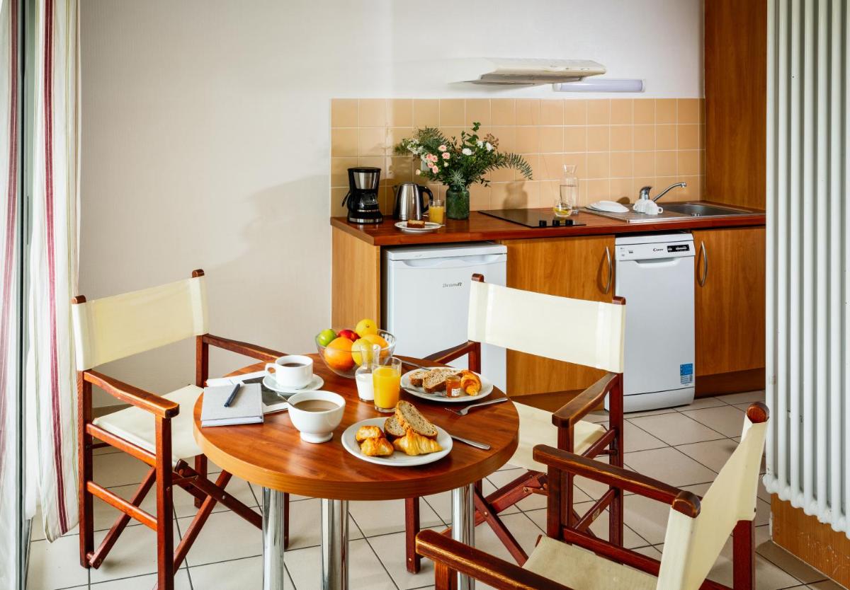 une cuisine avec une table en bois sur laquelle se trouvent des aliments dans l'établissement Résidences Valdys Thalasso & Spa de Rockroum, à Roscoff
