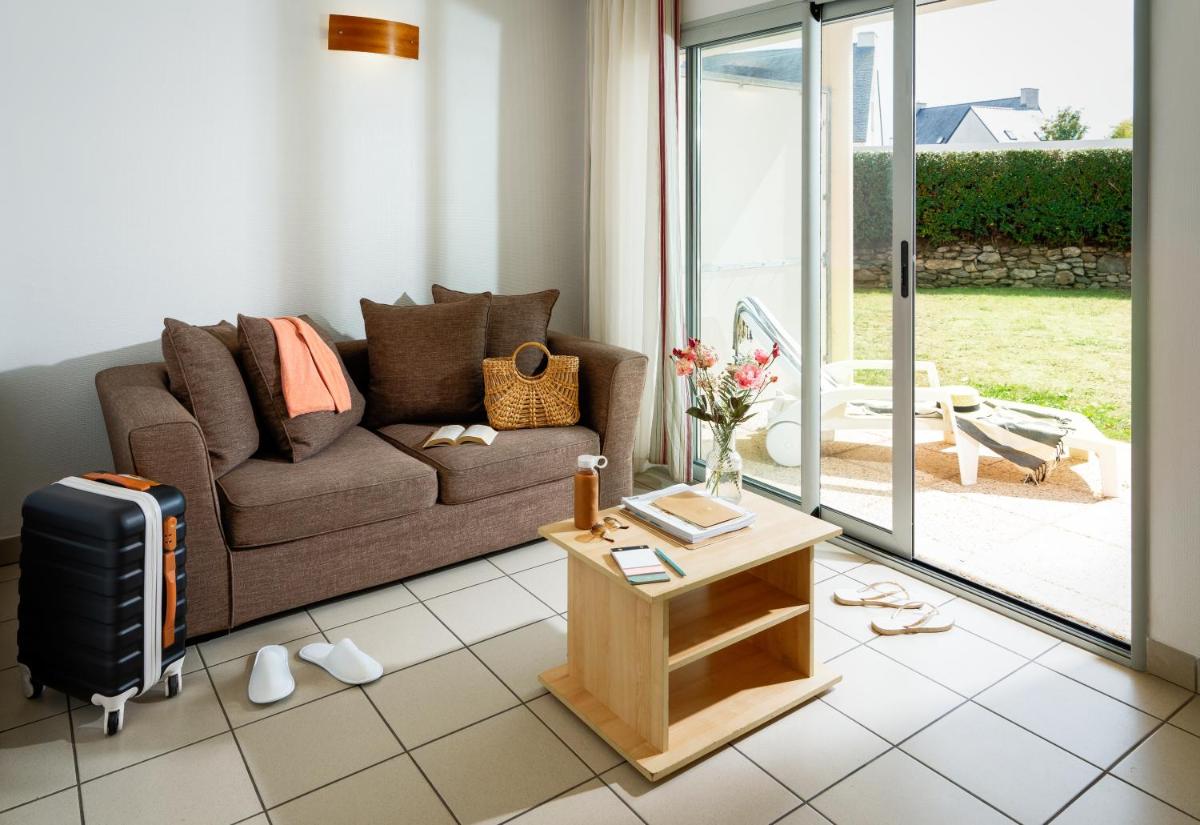 un salon avec un canapé et une table dans l'établissement Résidences Valdys Thalasso & Spa de Rockroum, à Roscoff
