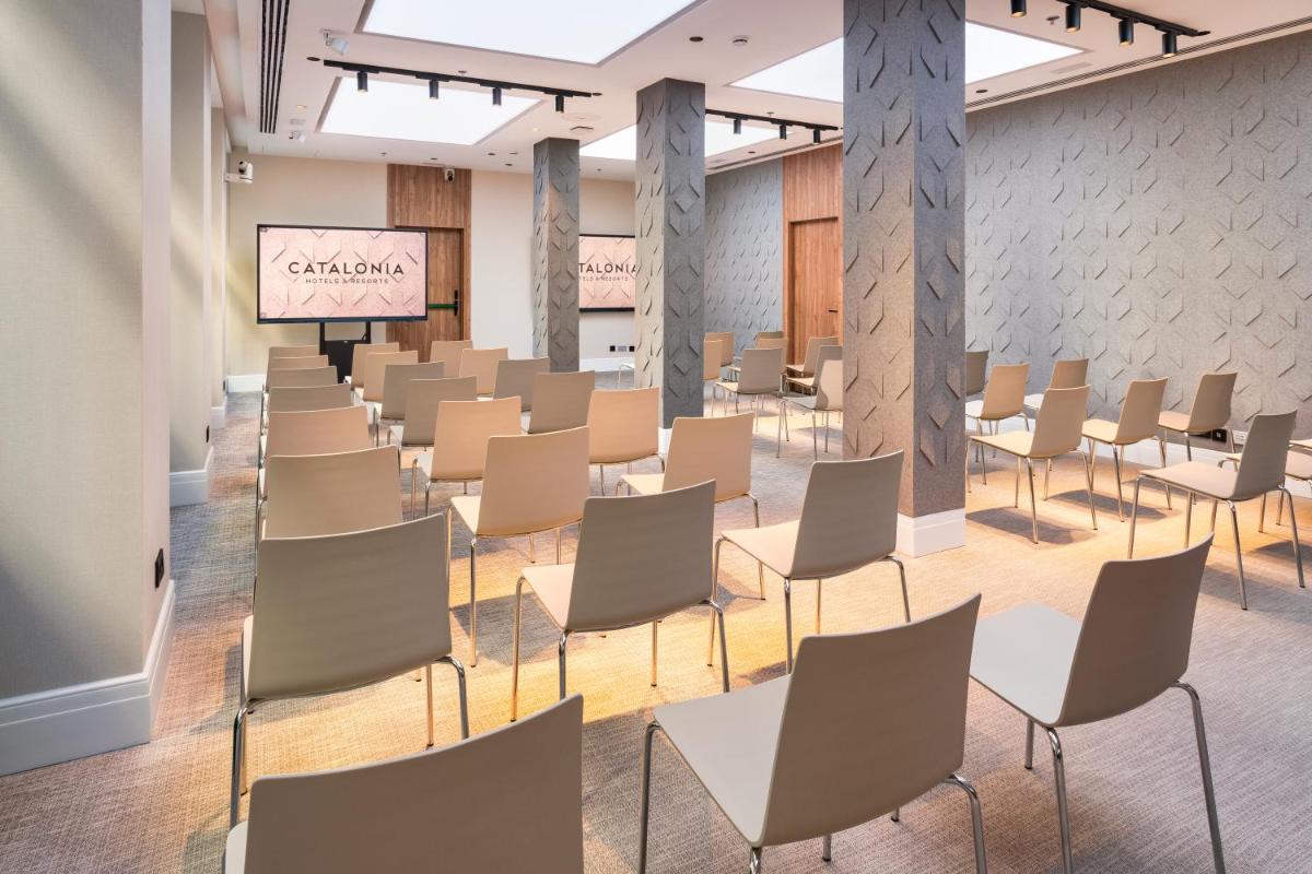 una sala de espera con sillas y una pantalla de proyección en Catalonia Atocha, en Madrid 56 fotos más