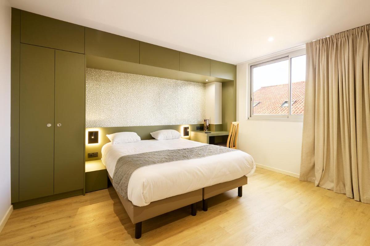 Un ou plusieurs lits dans un hébergement de l'établissement Hotel Du Commerce Spa