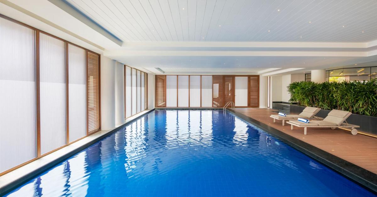 a large swimming pool in a building with windows at The Residency Towers Puducherry in Puducherry