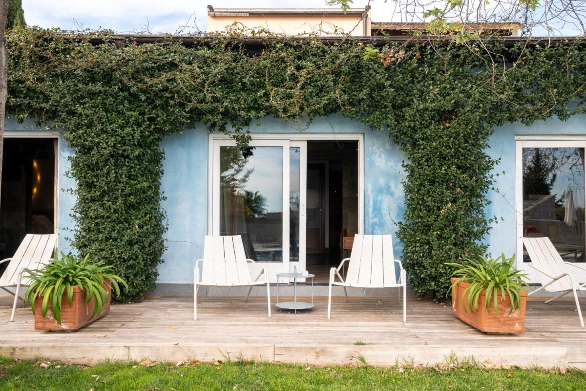 una casa azul con sillas y plantas blancas en Hotel Boutique Mas Passamaner, en La Selva del Camp