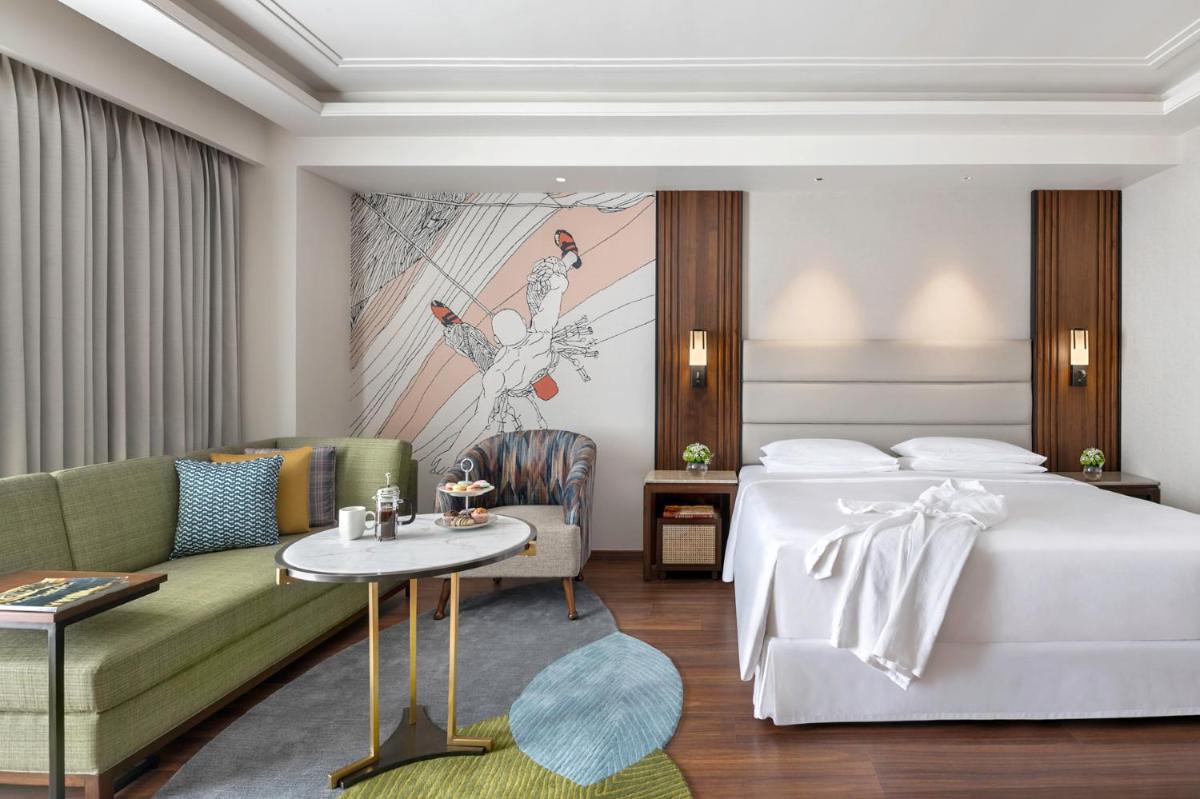 a hotel room with a bed and a couch at Hyatt Centric Rajpur Road Dehradun in Dehradun