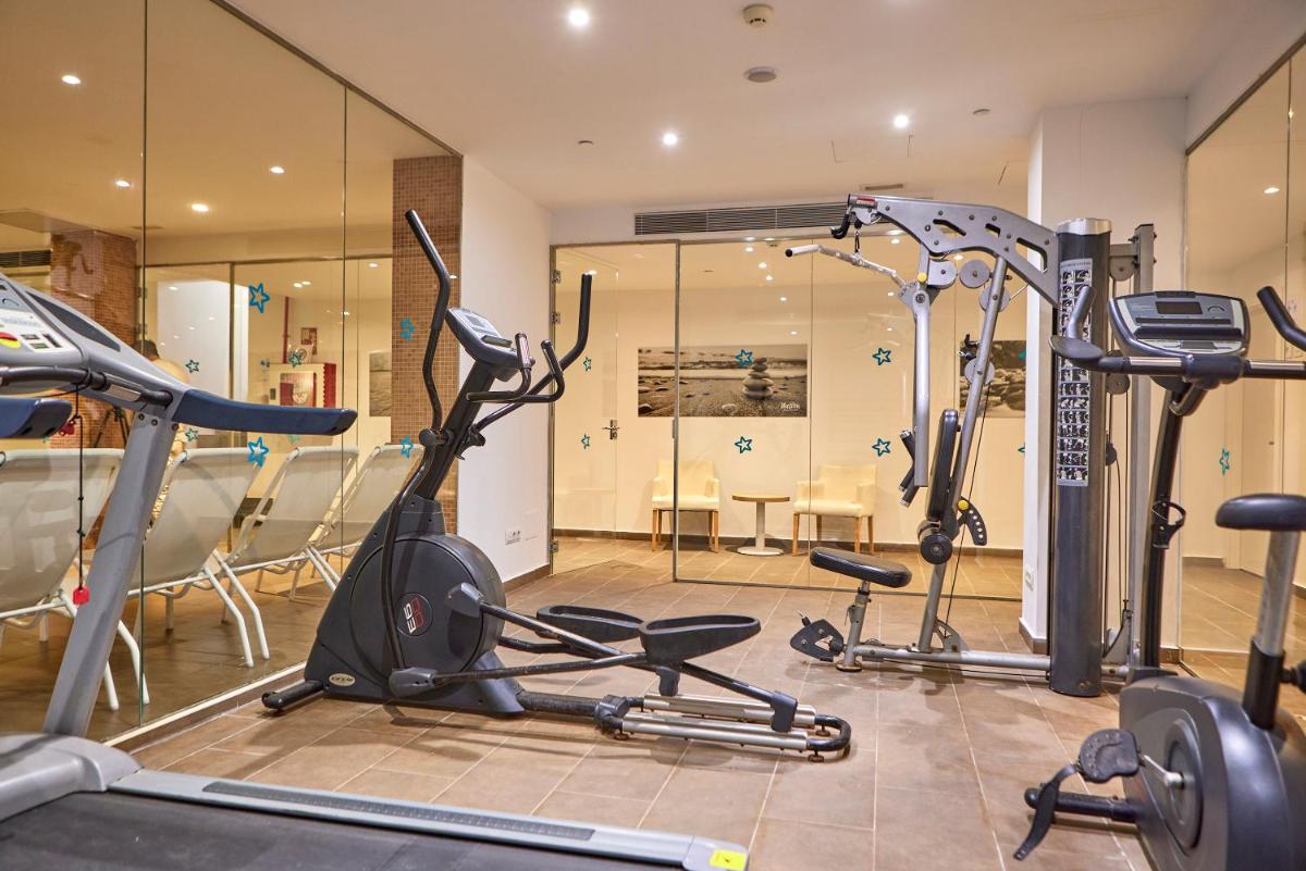 Un gimnasio con tres bicicletas estáticas en una habitación. en Hotel Ilusion Calma & Spa, en Can Pastilla