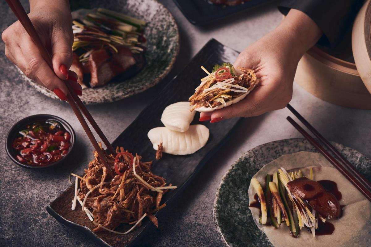a person holding aplate of food on a table at FIVE Palm Jumeirah Dubai in Dubai