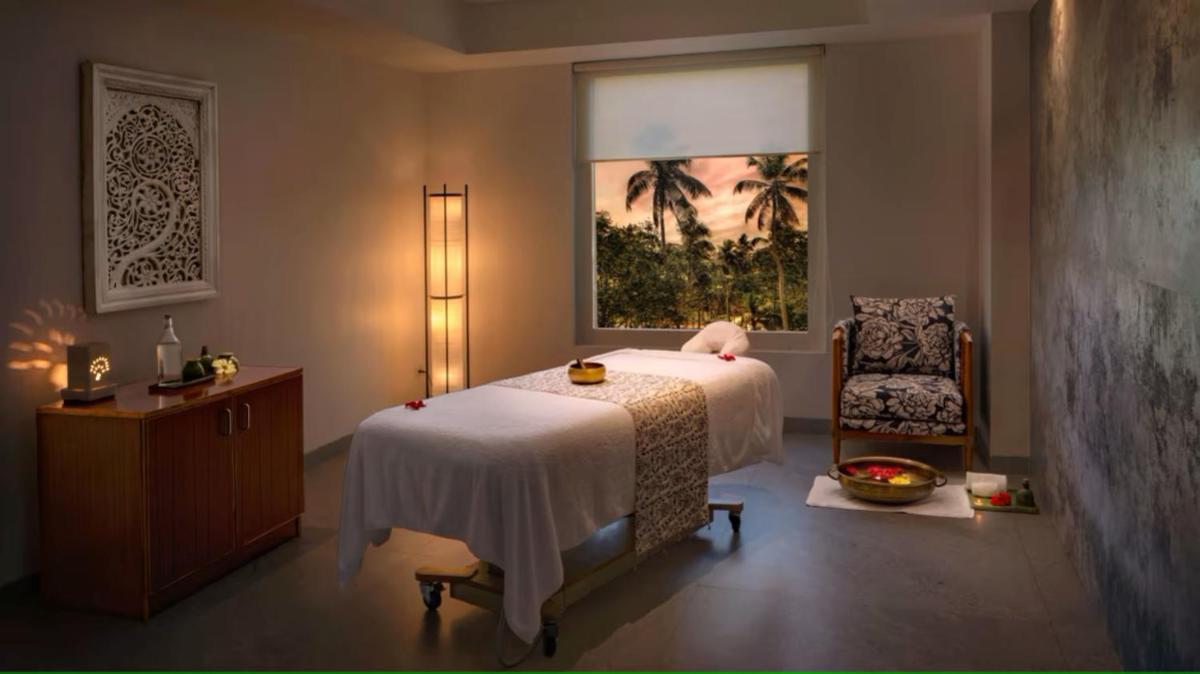 a bedroom with a bed and a window and a chair at O by Tamara, Trivandrum in Trivandrum