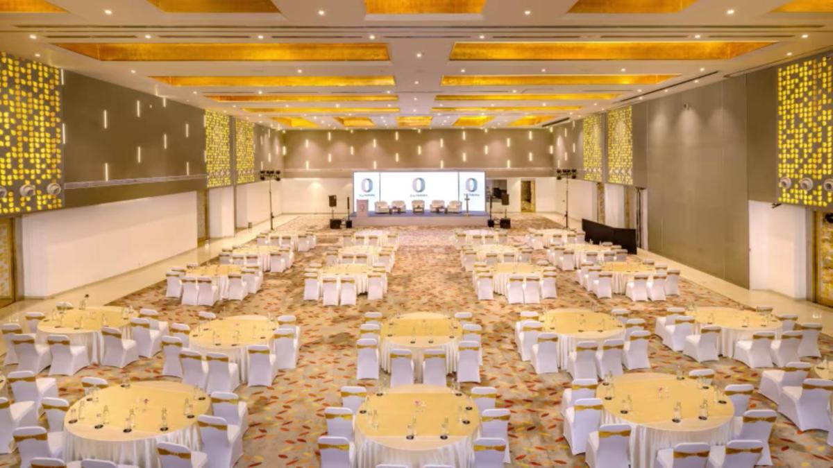 a large banquet hall with yellow tables and white chairs at O by Tamara, Trivandrum in Trivandrum