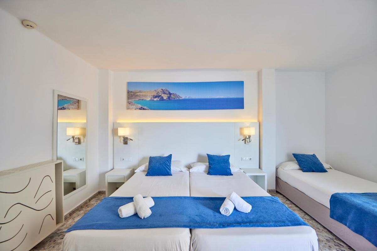 Dos camas en una habitación con azul y blanco. en Hotel Ilusion Calma & Spa, en Can Pastilla