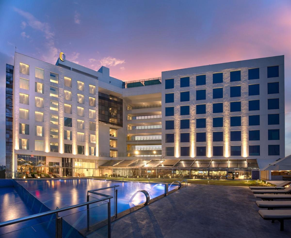 a hotel with a pool in front of two buildings at O by Tamara, Trivandrum in Trivandrum