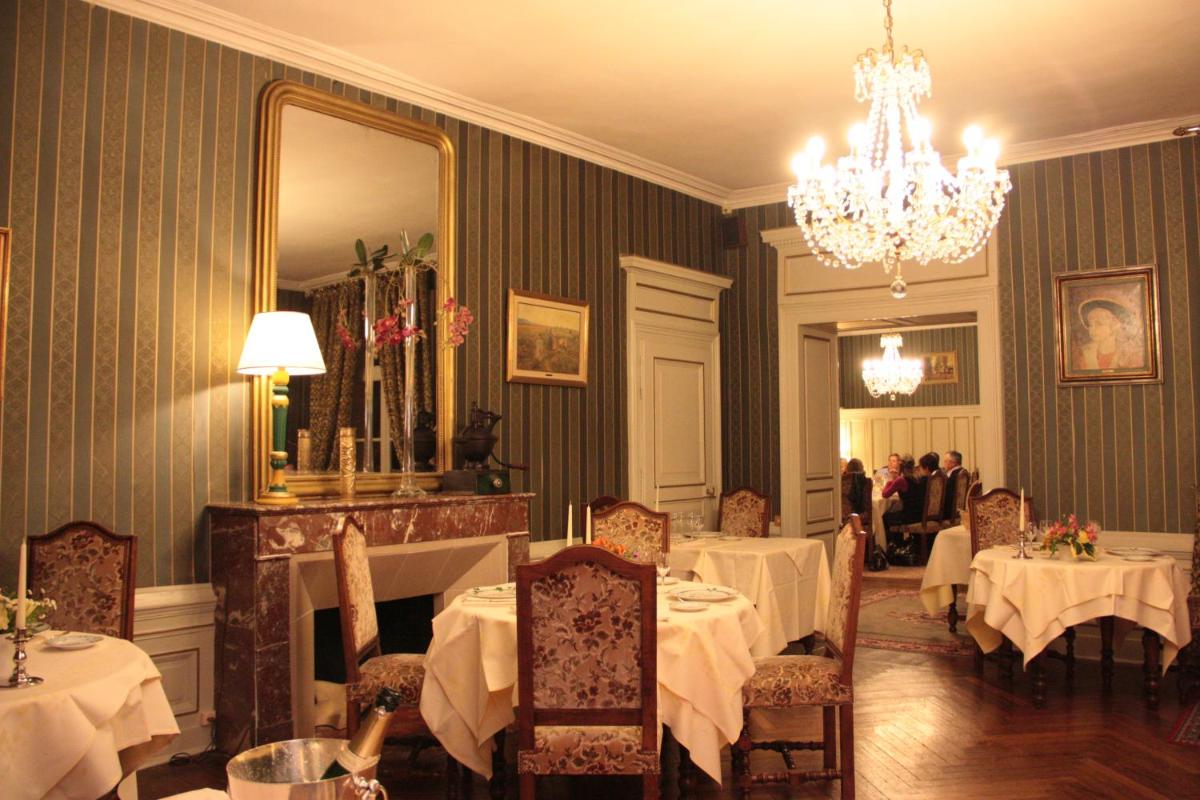 une salle à manger avec des tables, un miroir et un lustre dans l'établissement Château des Monthairons Hôtel Restaurant GastroMaison Spa privatif, à Les Monthairons