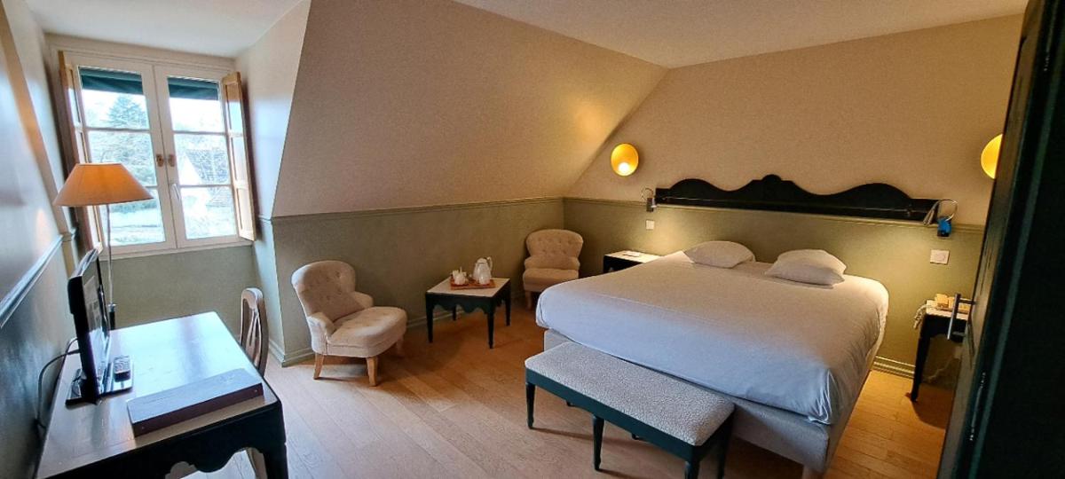 Un ou plusieurs lits dans un hébergement de l'établissement Logis Hostellerie des Clos et restaurant Bistrot des grands crus