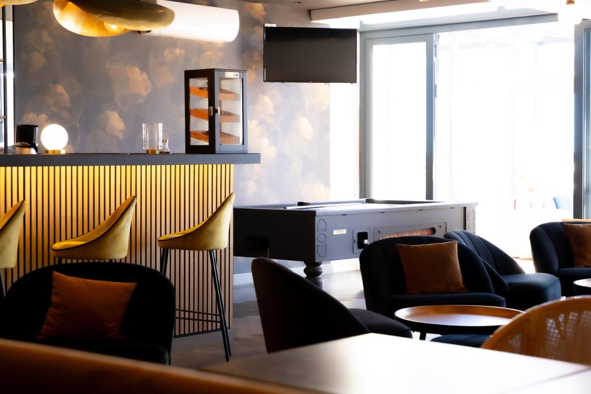 une salle d'attente avec des chaises, une table et un piano dans l'établissement Hôtel Mar I Cel & Spa, à Canet