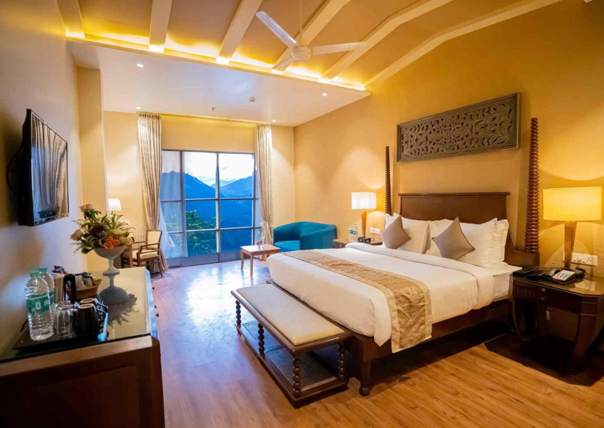 a bedroom with a large bed and a large window at Essentia Luxury Resort & Spa Udaipur in Udaipur