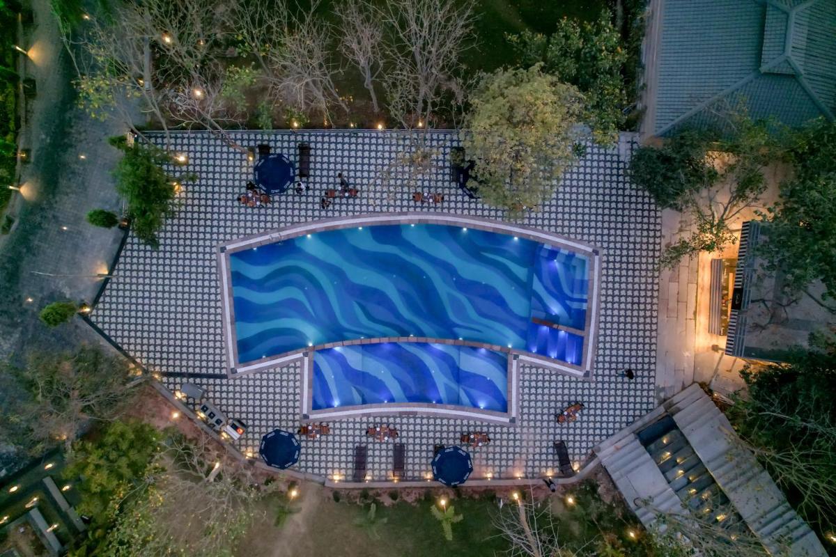 an overhead view of a swimming pool at night at Essentia Luxury Resort & Spa Udaipur in Udaipur