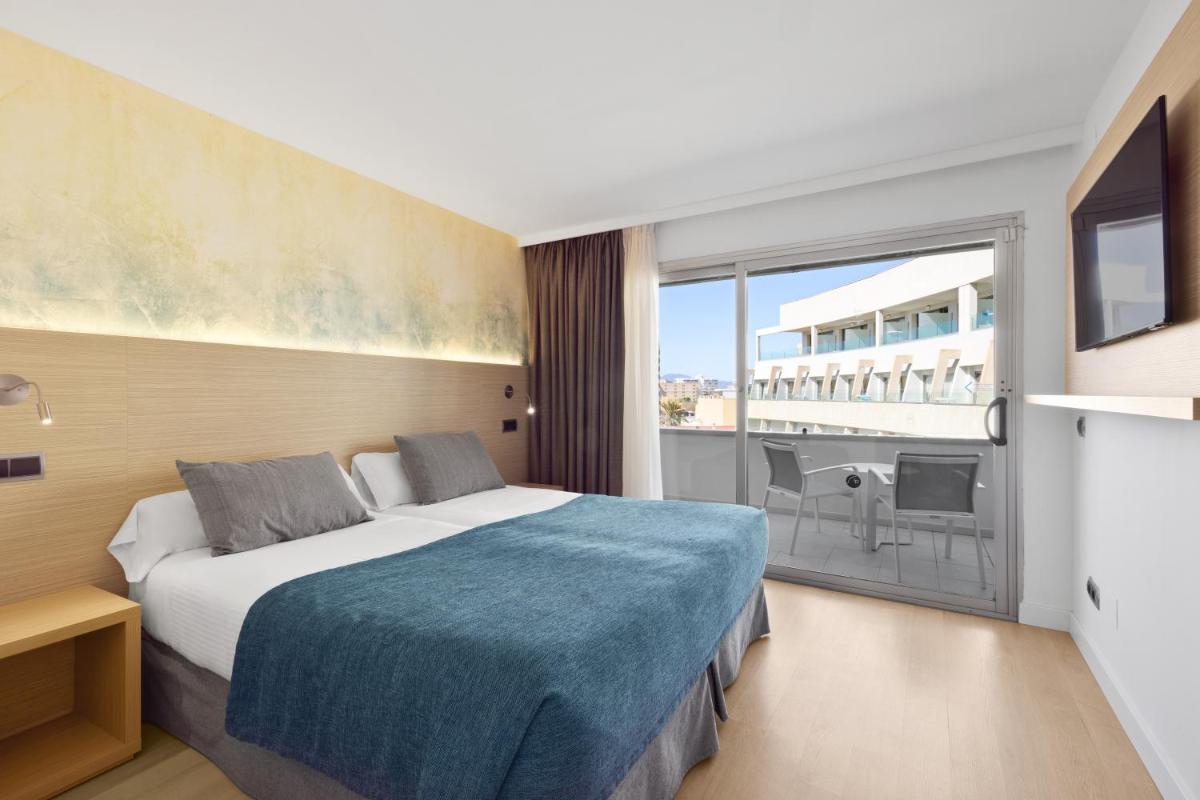 Una habitación de hotel con una cama y una ventana grande. en Aparthotel Fontanellas Playa, en Playa de Palma