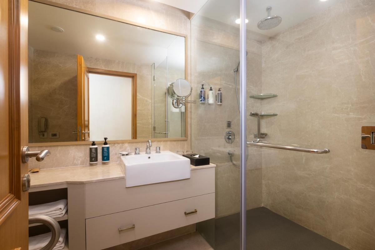 a bathroom with a sink and a shower at Novotel Hyderabad Airport in Hyderabad