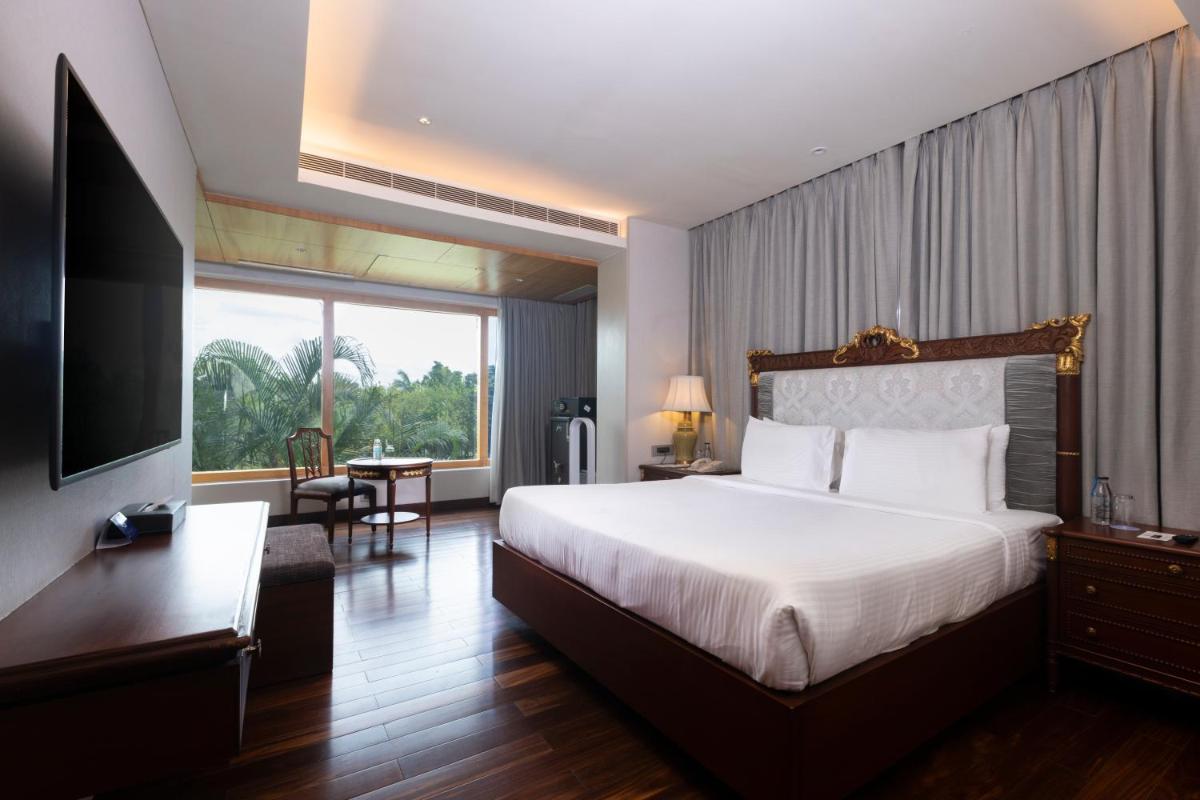 a hotel room with a bed and a large window at Novotel Hyderabad Airport in Hyderabad