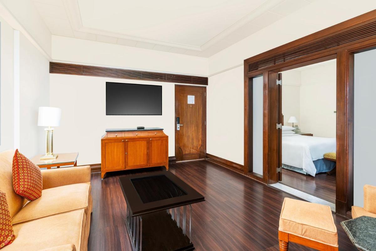 a living room with a bed and a television at Hyderabad Marriott Hotel & Convention Centre in Hyderabad