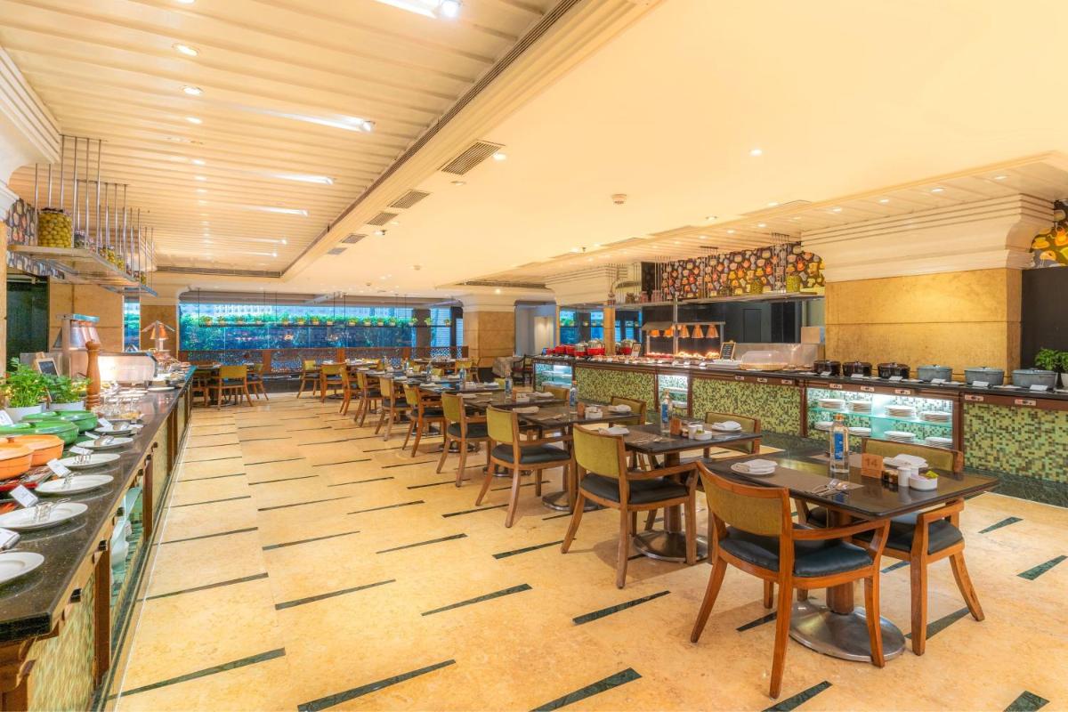 a restaurant with tables and chairs and a bar at Hyderabad Marriott Hotel & Convention Centre in Hyderabad