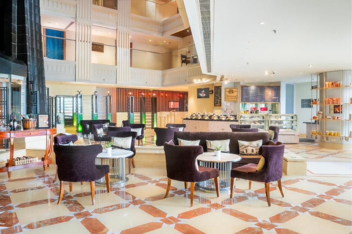 a restaurant with tables and chairs in a lobby at Hyderabad Marriott Hotel & Convention Centre in Hyderabad