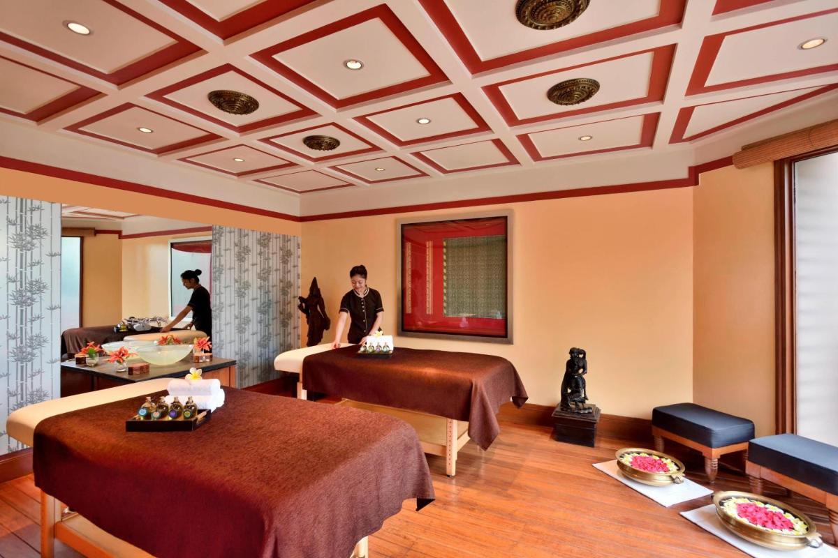 a hotel room with two beds and people in it at Hyderabad Marriott Hotel & Convention Centre in Hyderabad