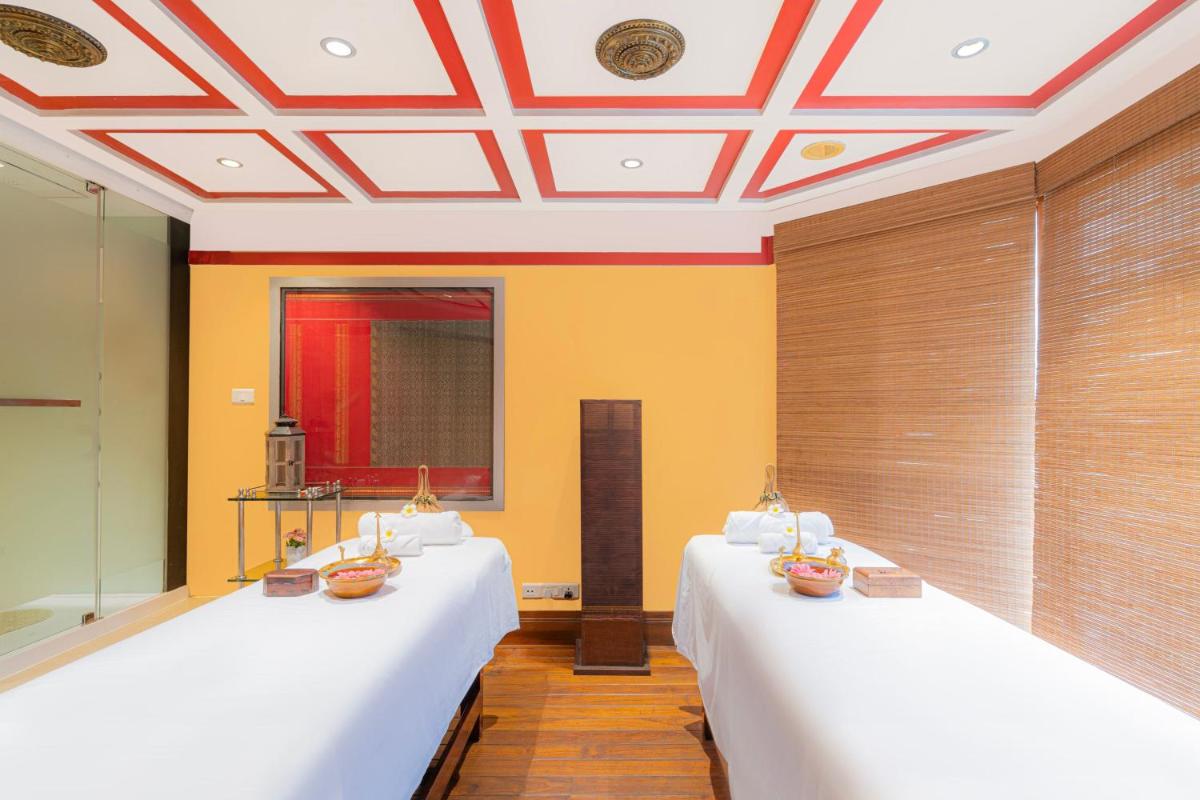 two beds in a room with yellow walls at Hyderabad Marriott Hotel & Convention Centre in Hyderabad