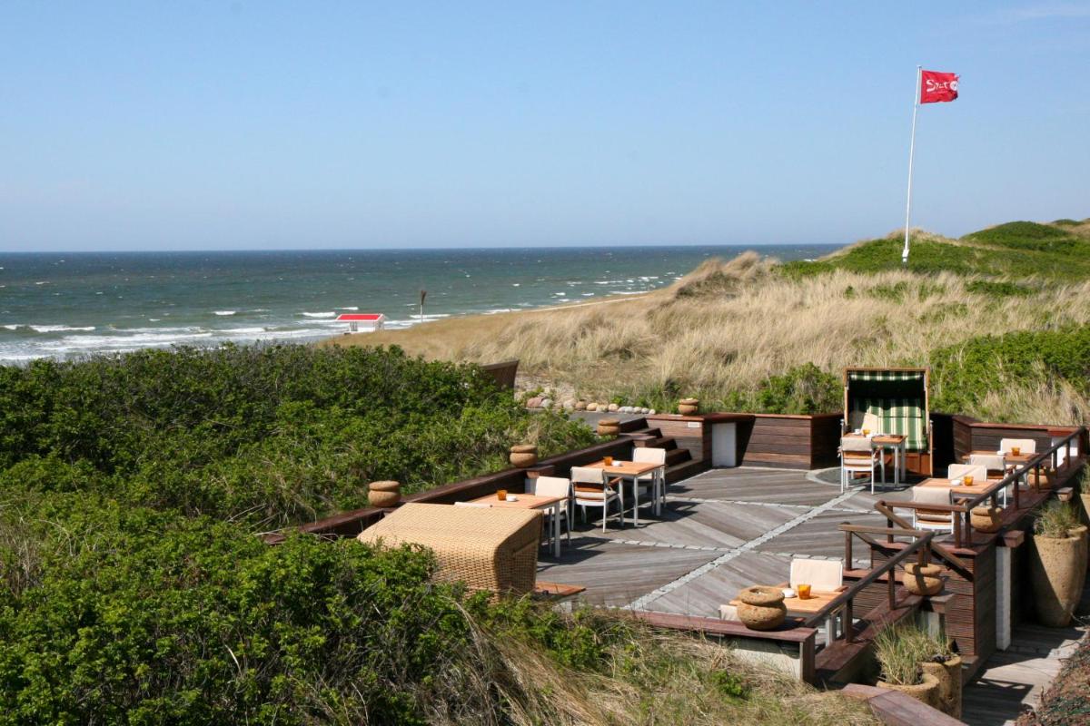 ein Restaurant am Strand mit dem Meer im Hintergrund in der Unterkunft Söl'ring Hof in Rantum