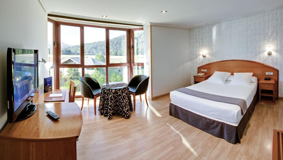 una habitación de hotel con una cama y un televisor en Hotel Spa Villa Pasiega, en Hoznayo