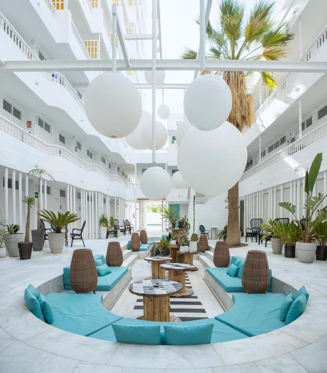 un vestíbulo con mesas, sillas y palmeras en Gold By Marina - Adults only, en Playa del Inglés