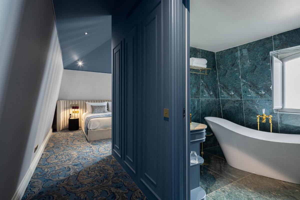 um banheiro com banheira e um quarto com cama. em MS Collection Aveiro - Palacete Valdemouro em Aveiro