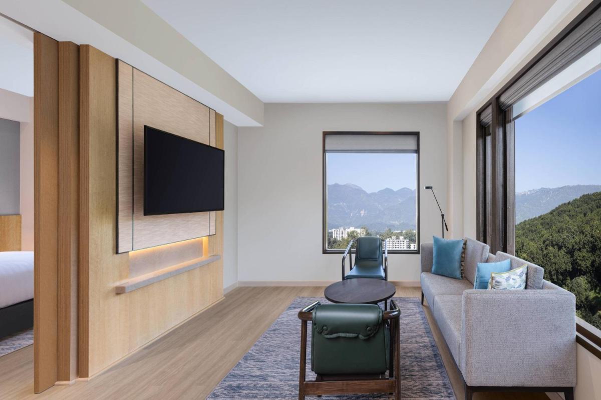 a hotel room with a couch and a tv at Fairfield by Marriott Dehradun in Dehradun