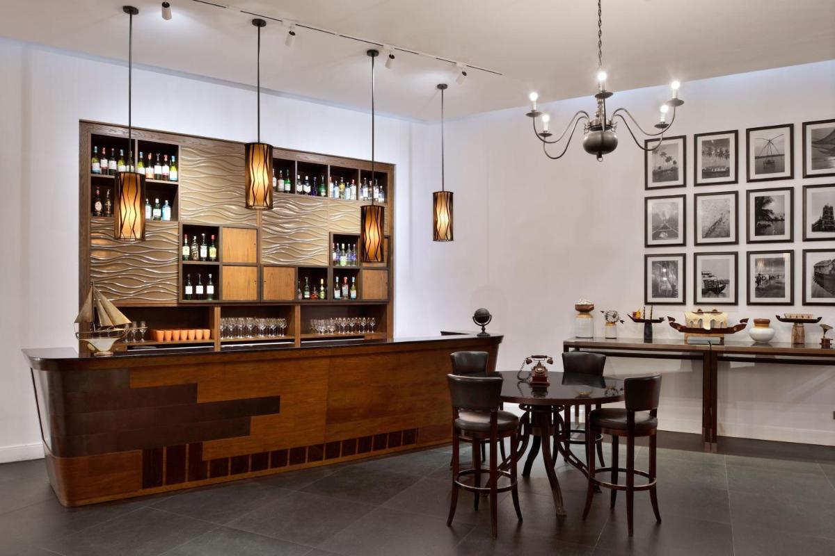 a bar in a restaurant with a table and chairs at Kochi Marriott Hotel in Cochin