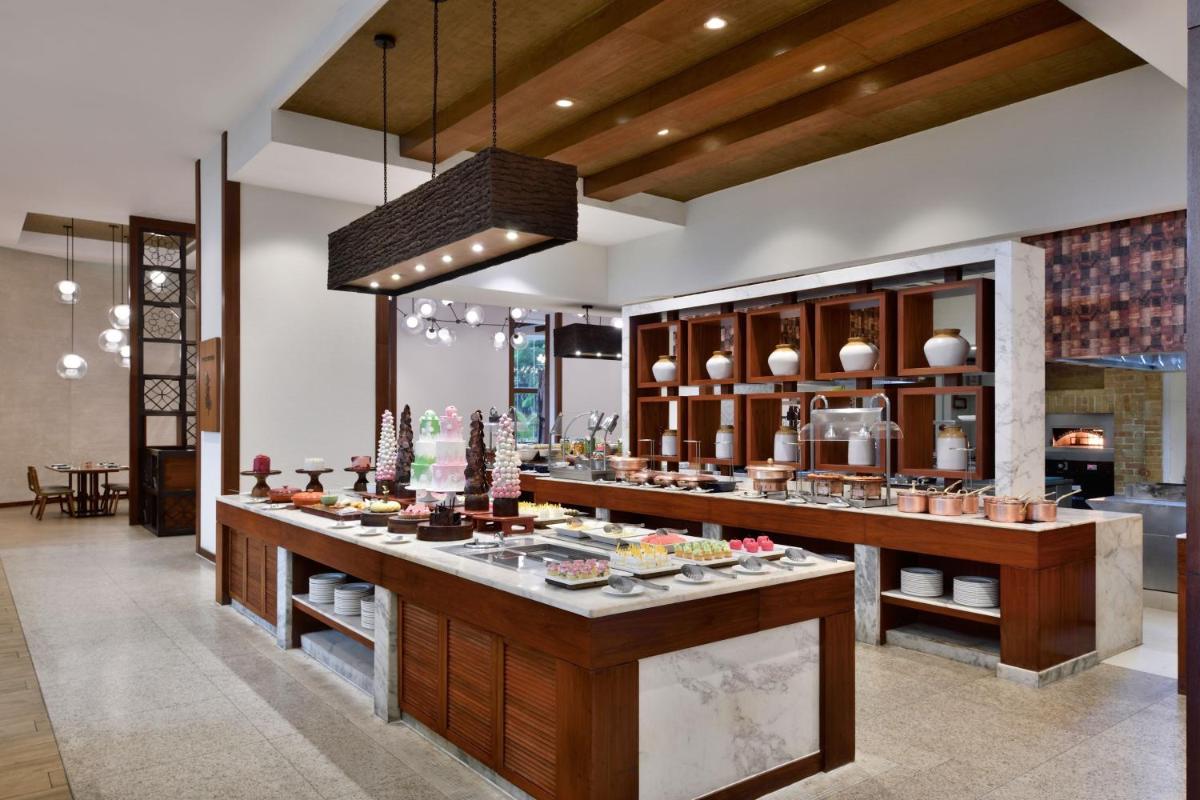 a kitchen with a counter with food on it at Kochi Marriott Hotel in Cochin