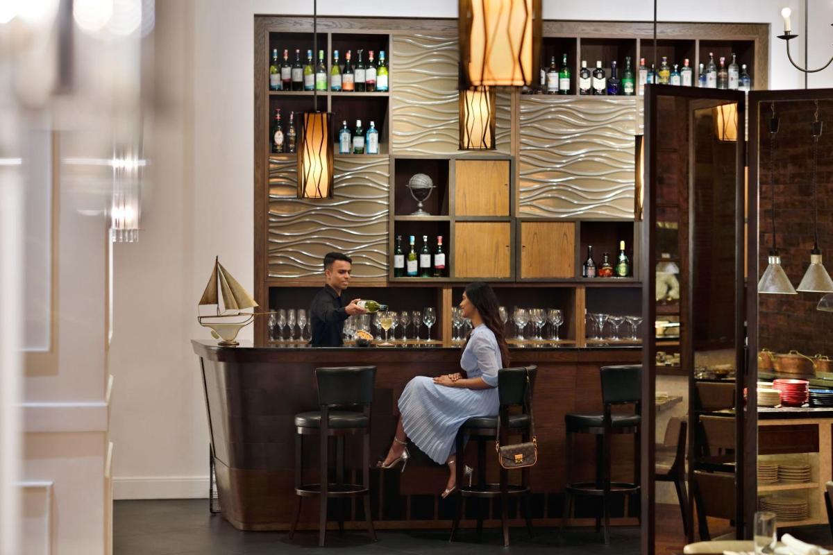 a man and a woman sitting at a bar at Kochi Marriott Hotel in Cochin