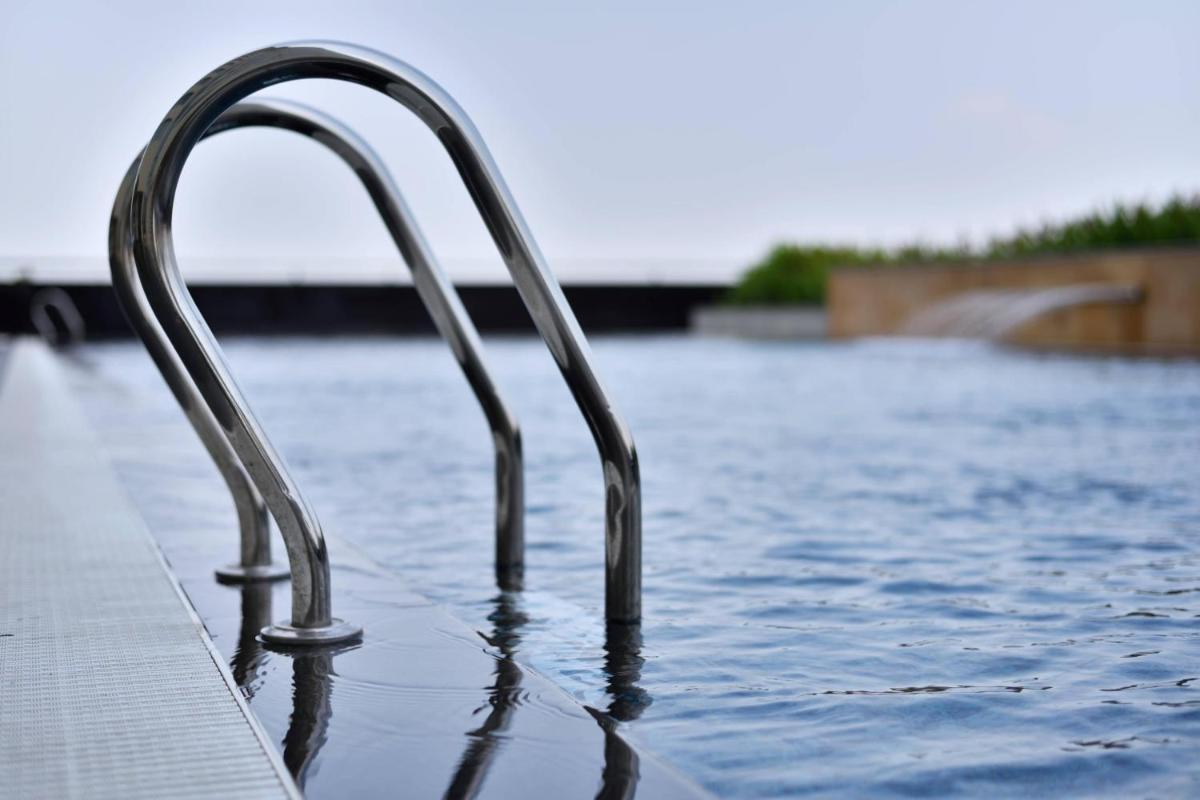 a pool with a metal railing in the water at Kochi Marriott Hotel in Cochin