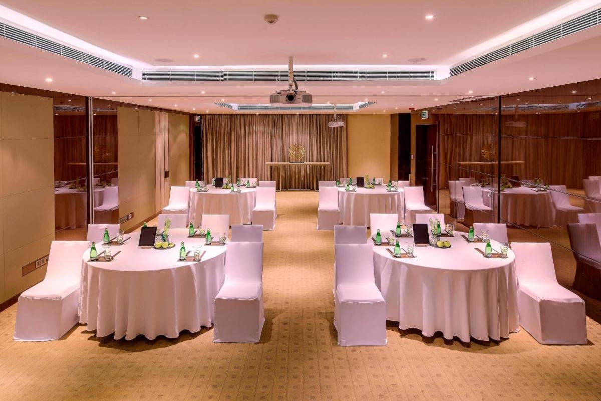 a banquet hall with white tables and white chairs at Kochi Marriott Hotel in Cochin