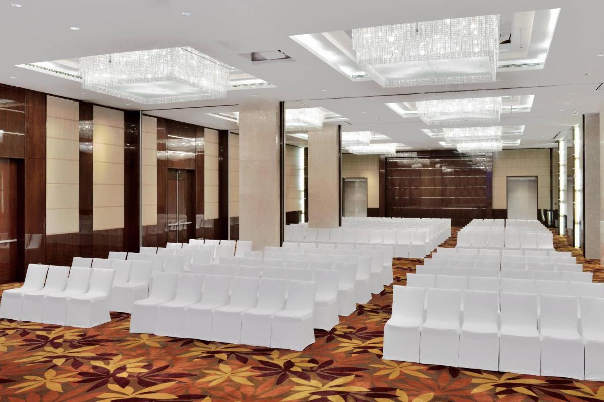 a row of white chairs in a room at Kochi Marriott Hotel in Cochin