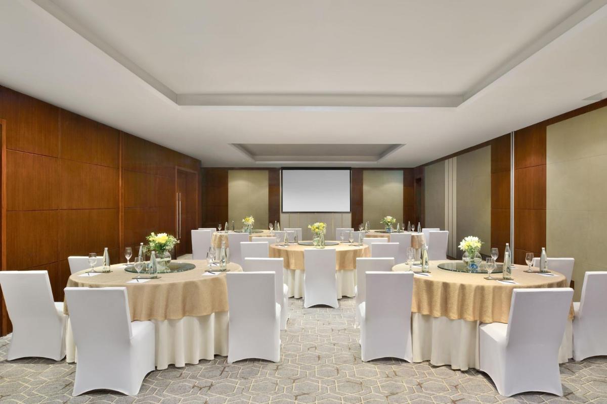a conference room with white tables and white chairs at Kochi Marriott Hotel in Cochin
